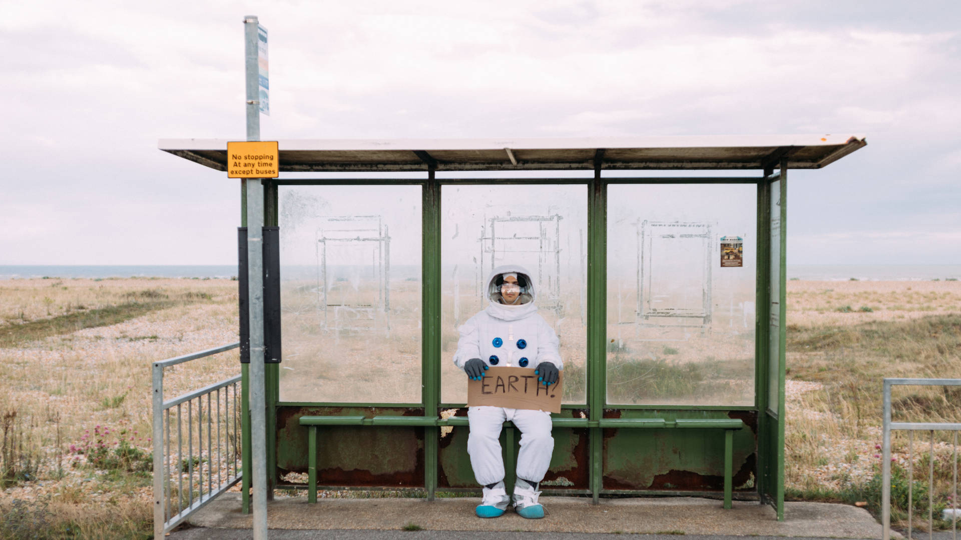 Astronaut At Bus Stop Wallpaper