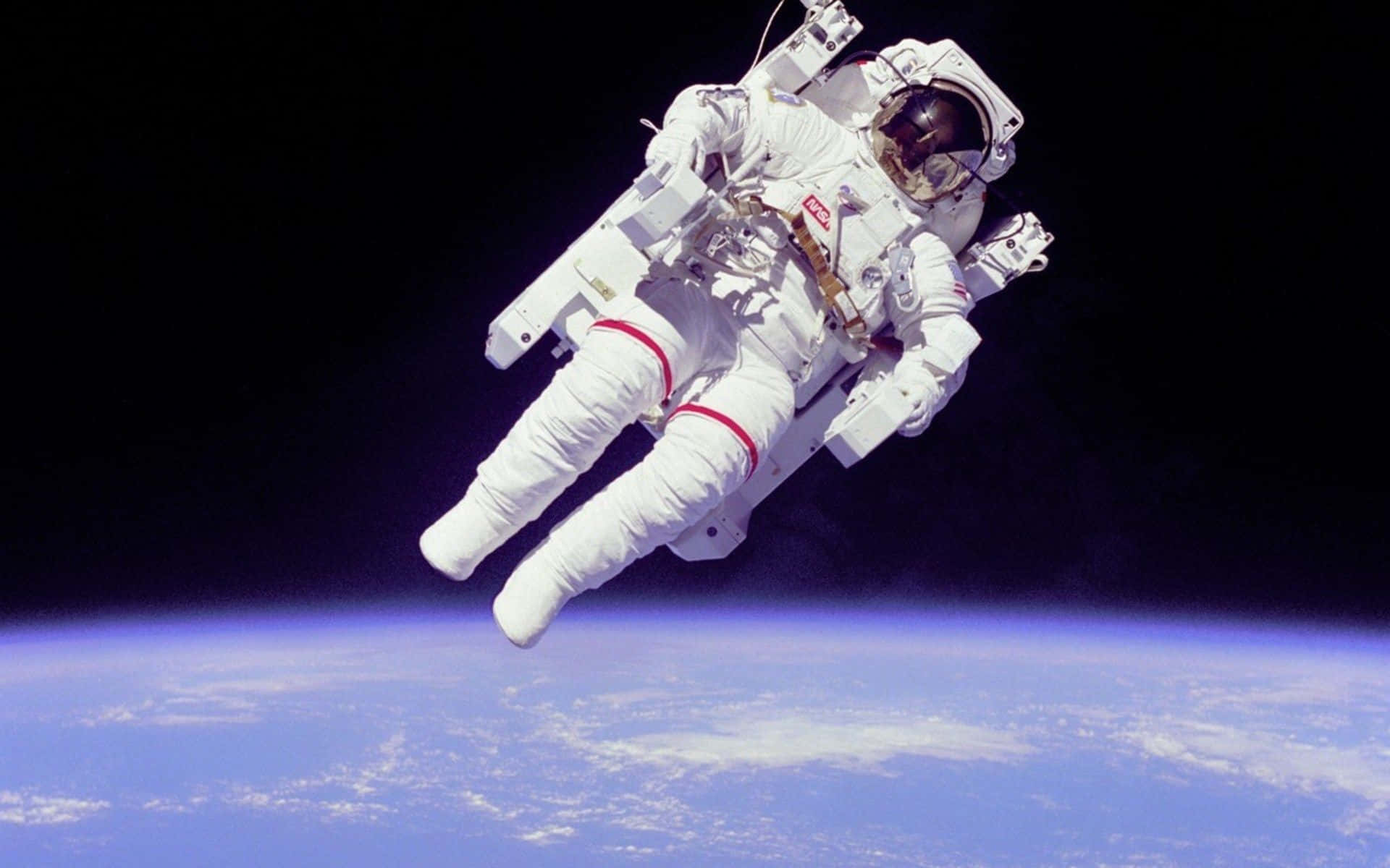 En ung astronaut udforsker den uendelige størrelse af rummet Wallpaper