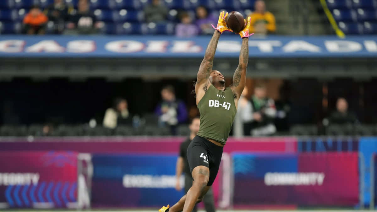 Athlete Catching Football During Combine Wallpaper