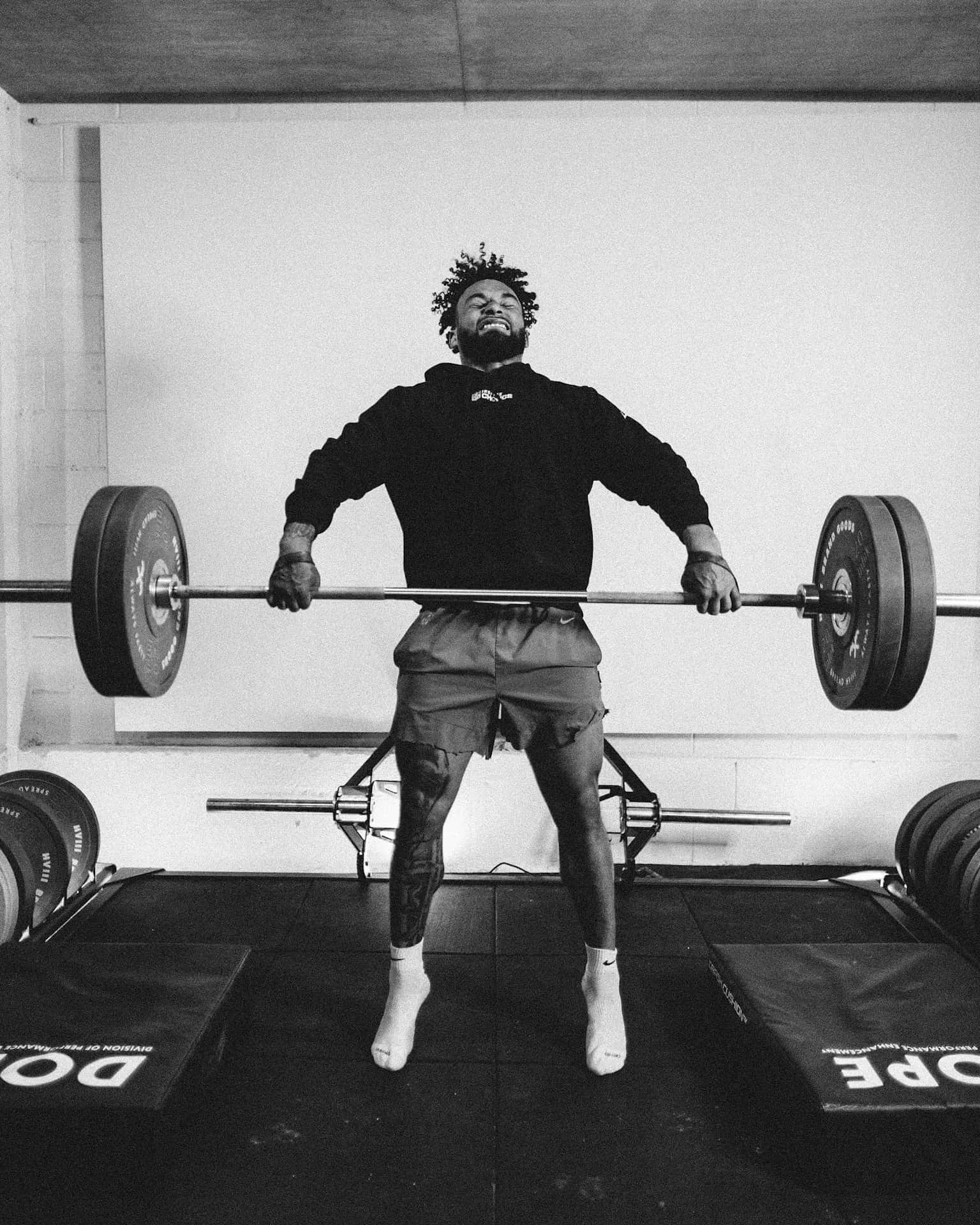 Athlete Lifting Weightsin Gym Wallpaper