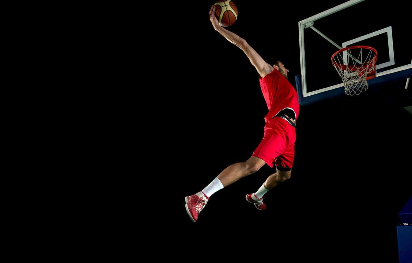 Basketball Athlete Leaps For A Dunk Wallpaper