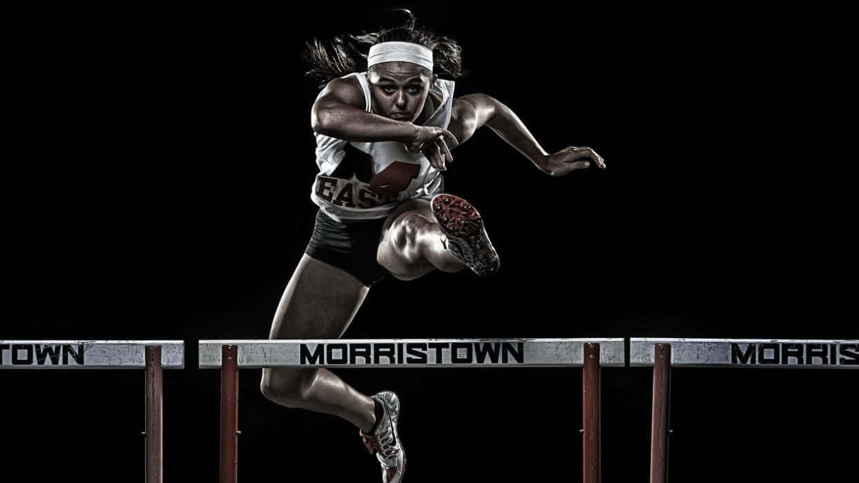 Woman Athlete In Hurdle Race Wallpaper