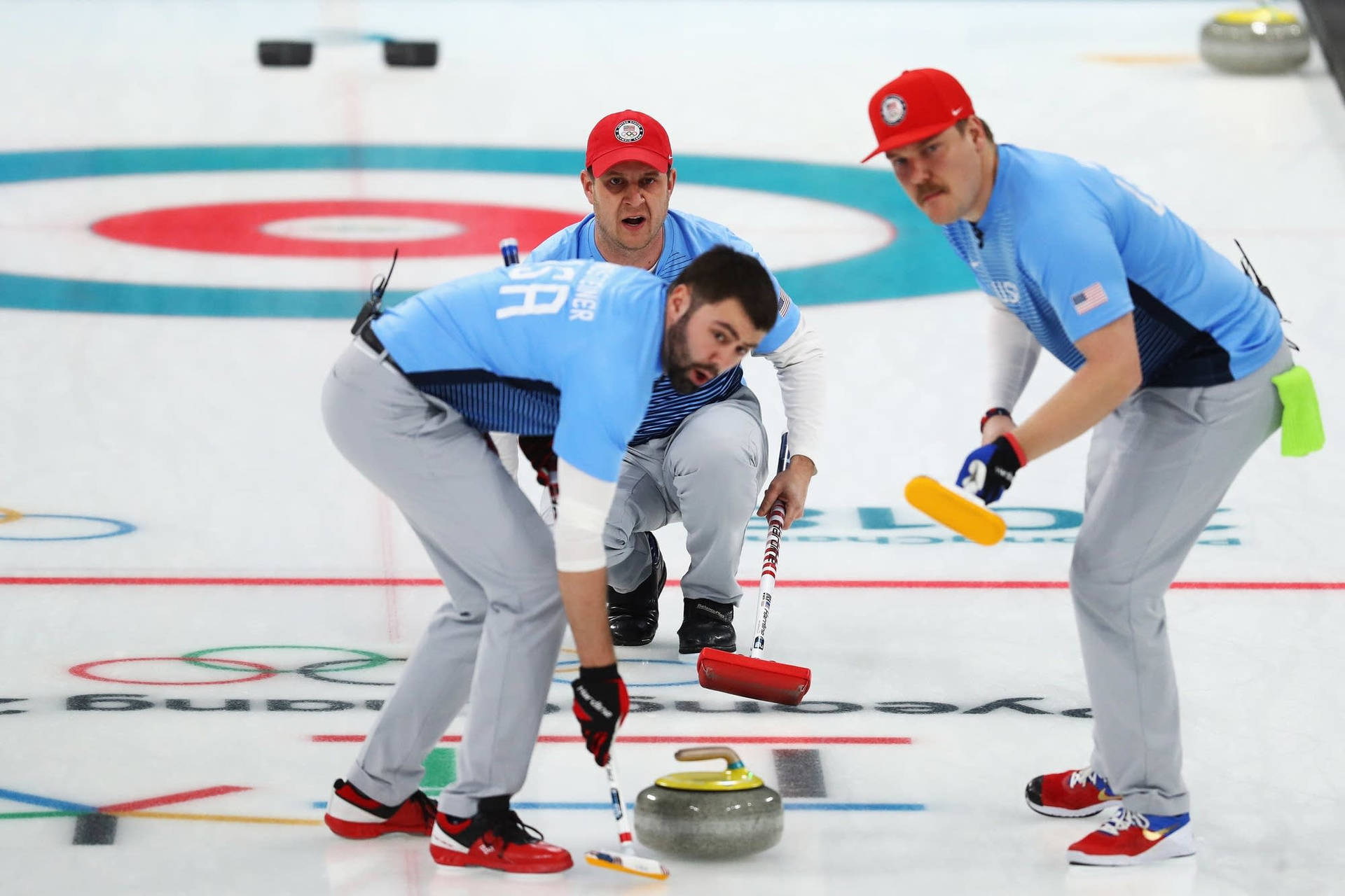 Athletes Curling The Stone On The Ice Wallpaper