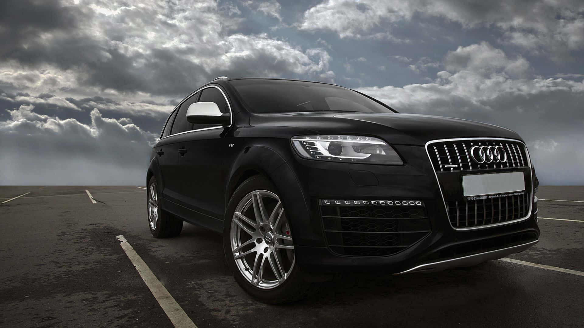 Breathtaking view of a sleek Audi Q7 on a scenic mountain road. Wallpaper
