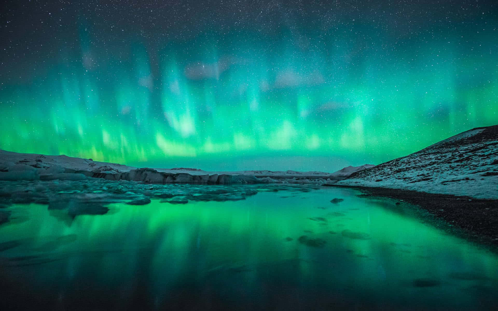 Majestic Aurora Borealis Over Snowy Mountains Wallpaper