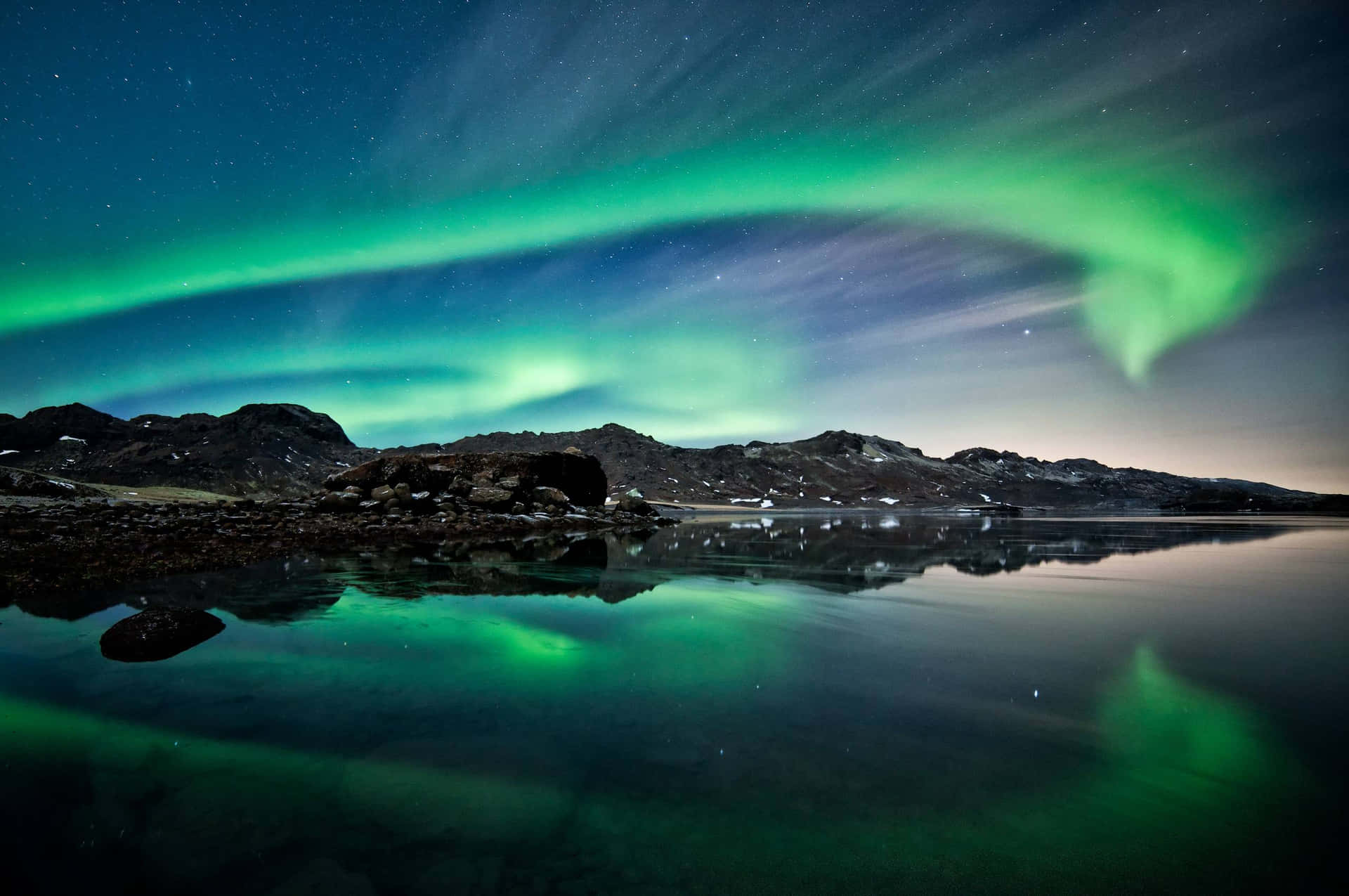 Enchanting Aurora Borealis Display Over a Tranquil Lake Wallpaper