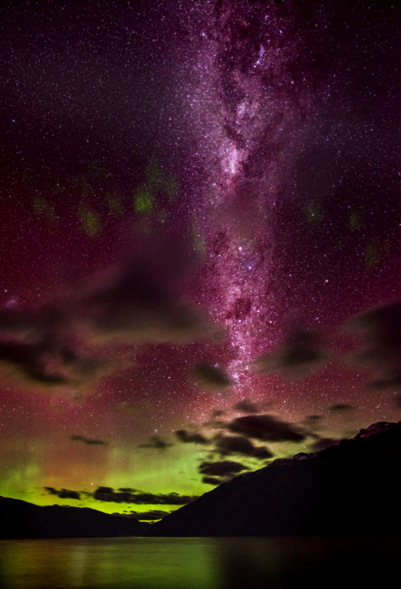 An aurora illuminates the night sky above the Canadian Rockies