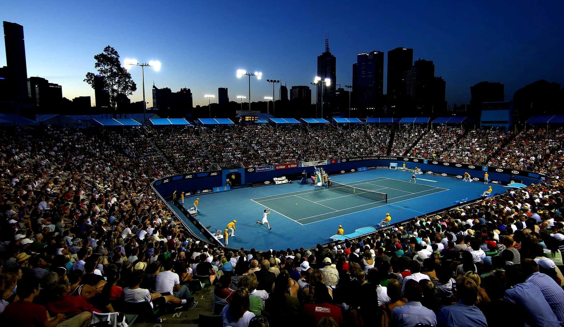 A Large Crowd Of People Watching A Tennis Match