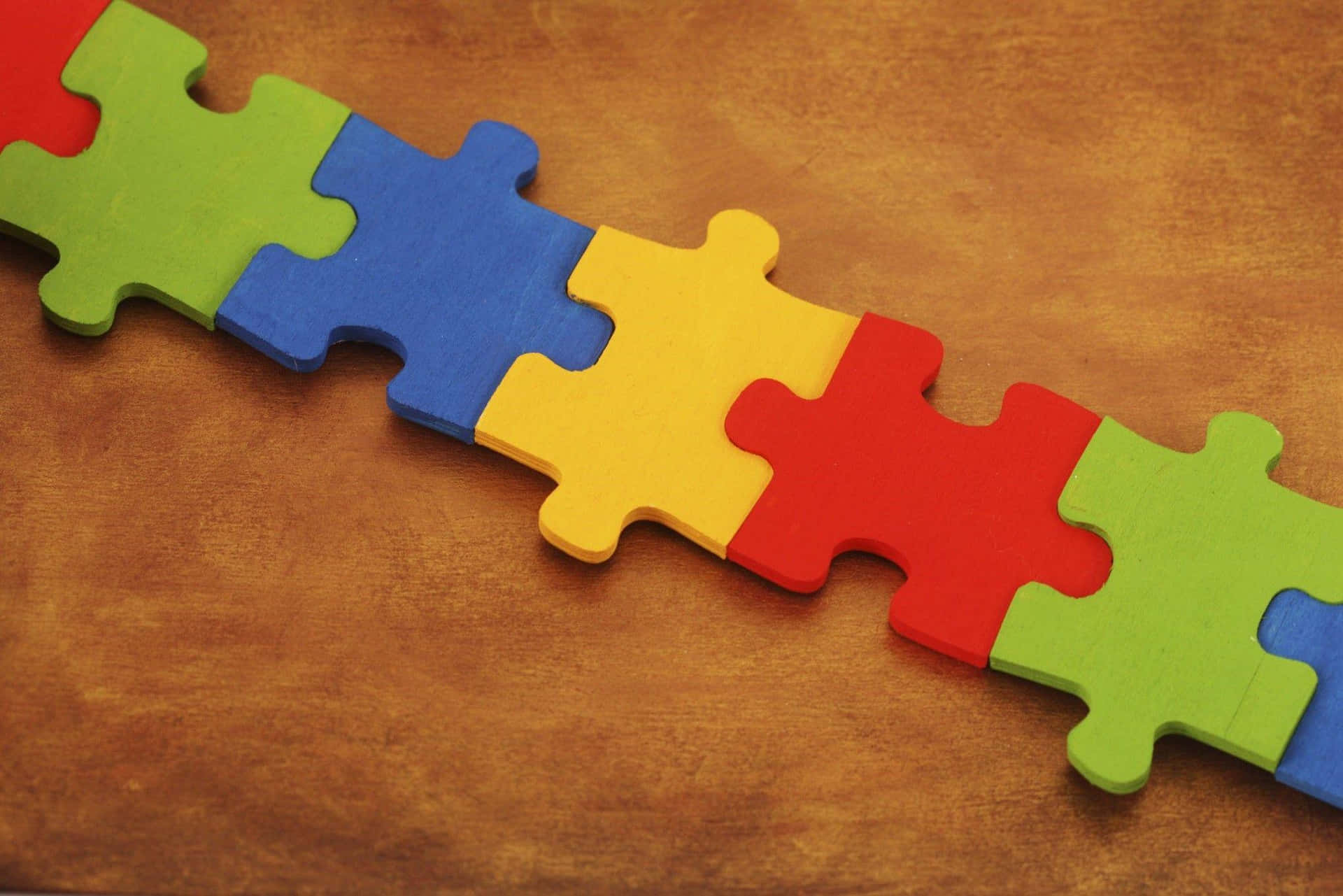 A Colorful Puzzle Piece On A Brown Background Wallpaper