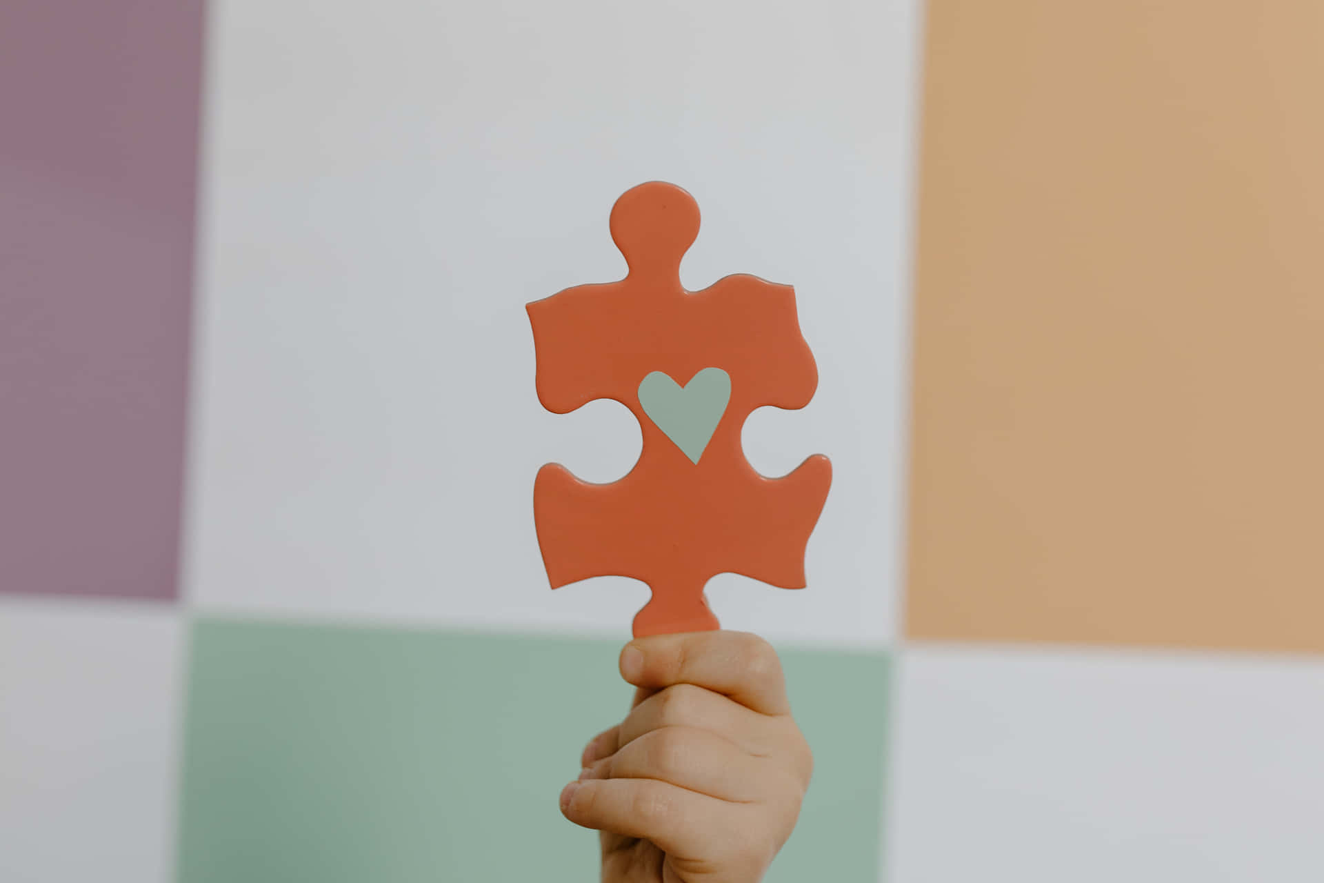 A Child Holding Up A Puzzle Piece With A Heart On It