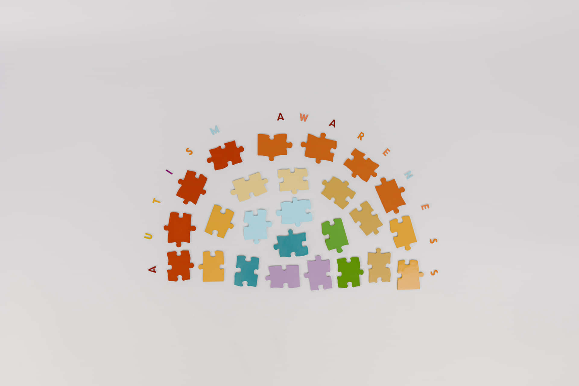 A Rainbow Of Colorful Puzzle Pieces On A White Background