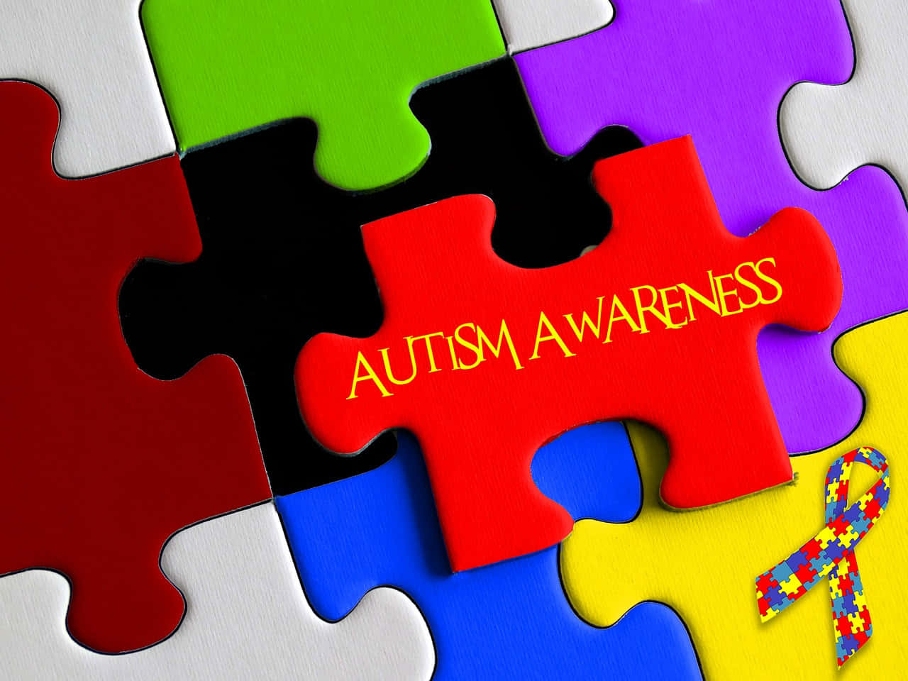 Autism Awareness Puzzle Pieces With The Word Autism Wallpaper