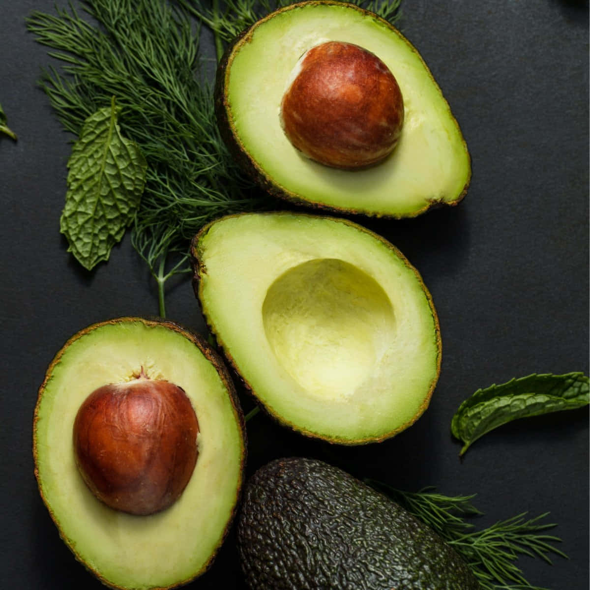 Avocados, Dill, Mint And Thyme On A Dark Background
