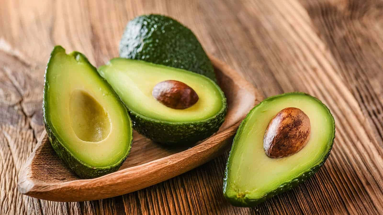 Avocados In A Wooden Bowl On A Wooden Table