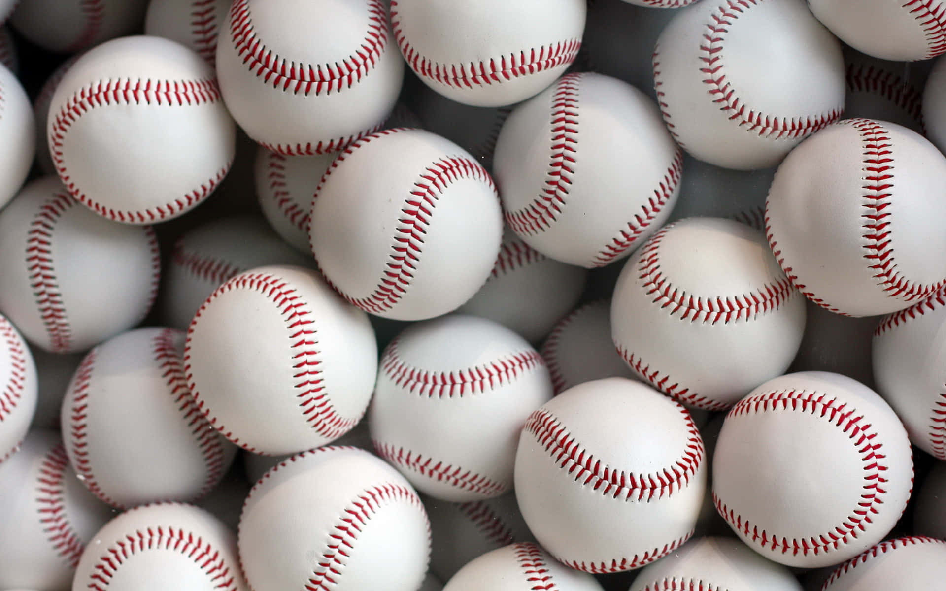 A Pile Of Baseballs Are Arranged In A Row Wallpaper