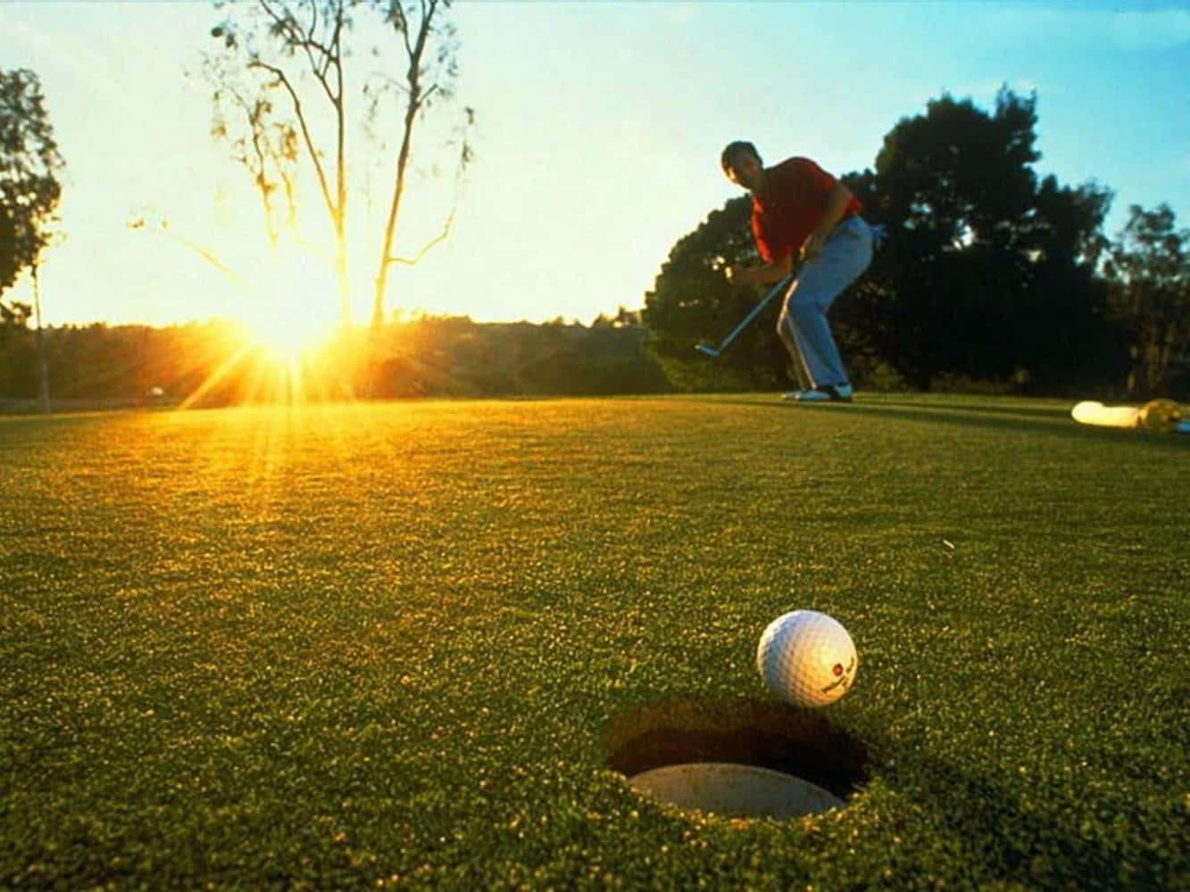 Drømmer golfspiller svingende på en smuk solrig dag. Wallpaper