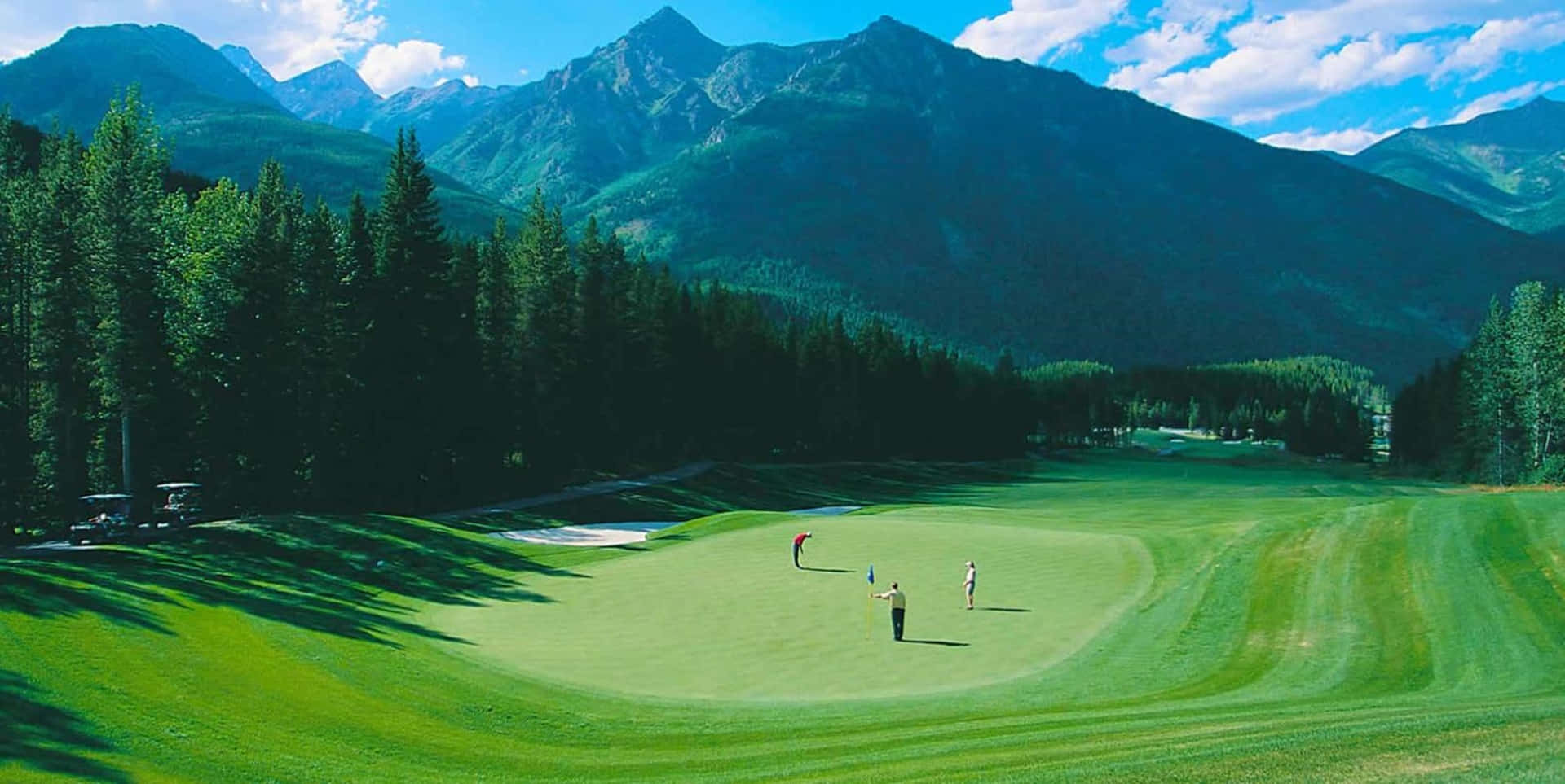 En golfbane med bjerge i baggrunden Wallpaper