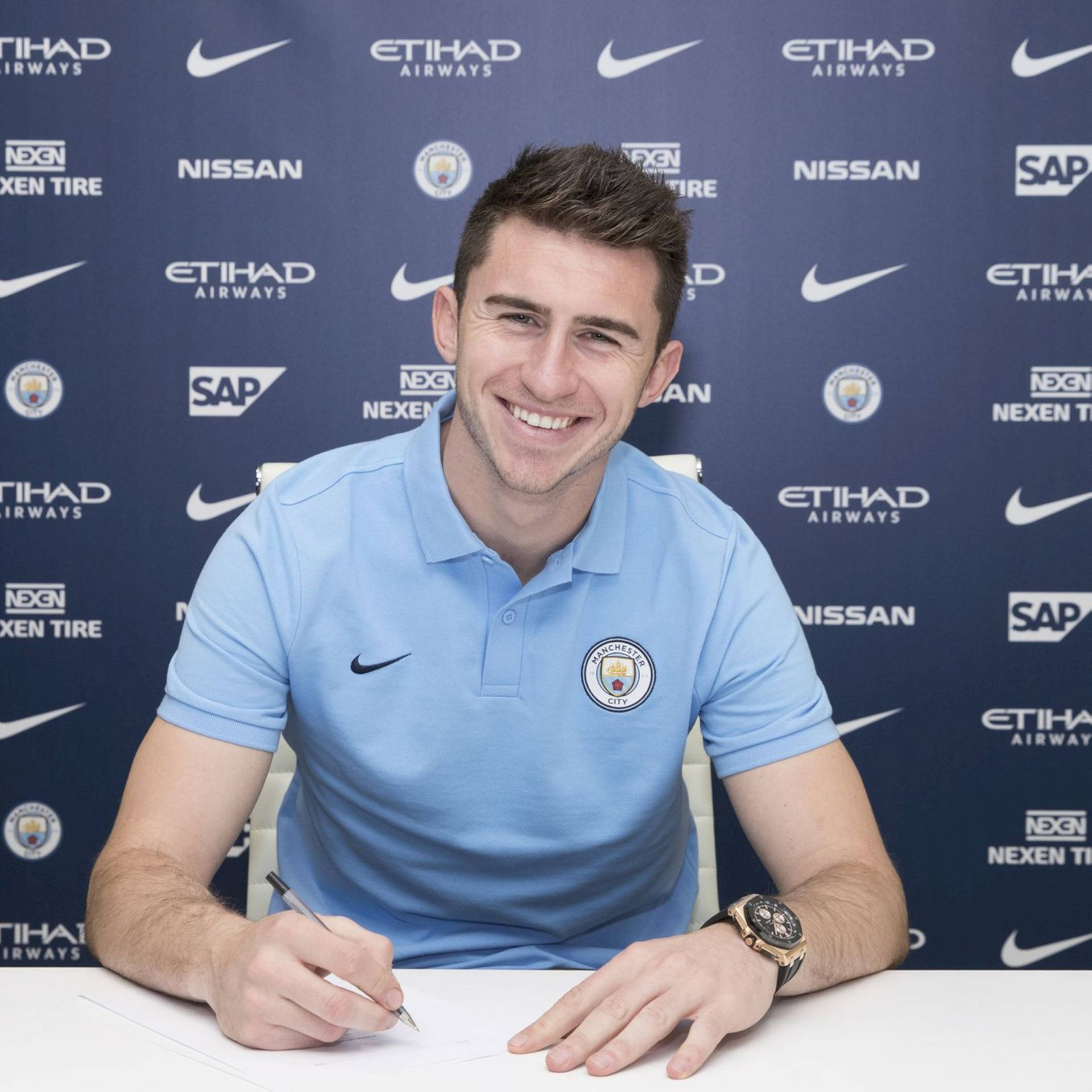 Aymeric Laporte Smiling And Holding Pen Wallpaper