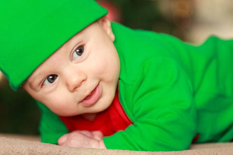 En lille dreng i grønt tøj smiler Wallpaper
