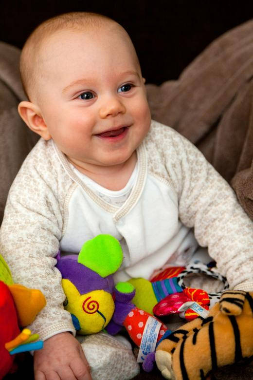 Baby Boy Smiling With Toys Wallpaper
