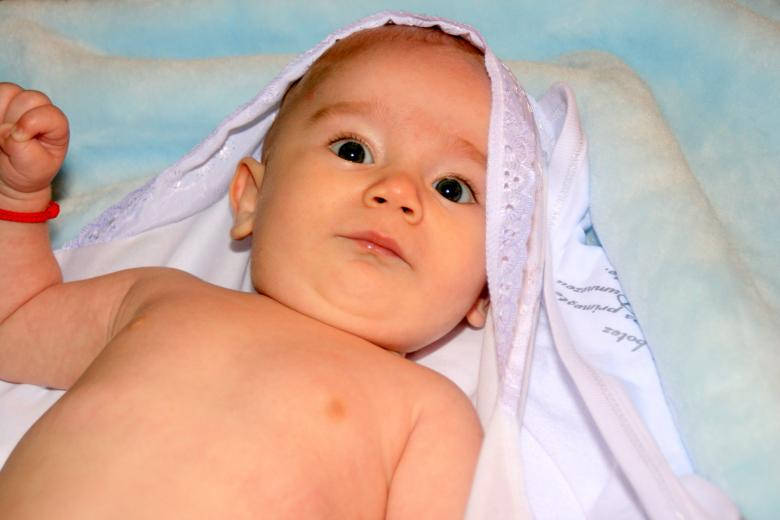 Baby Dreng iført rød armbånd smilende på brunt baggrund. Wallpaper