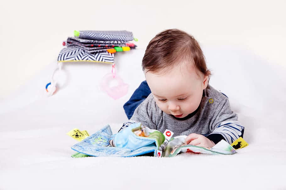 Baby Engaged With Educational Book Wallpaper