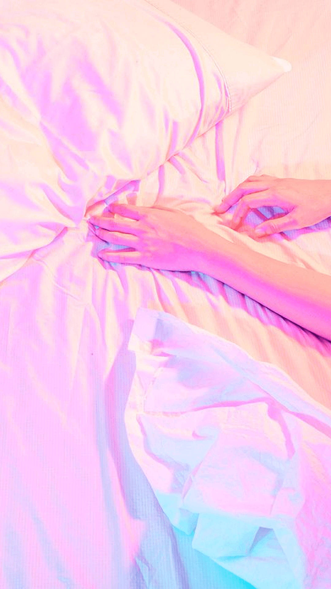 En kvinde ligger på en seng med et pink tæppe. Wallpaper