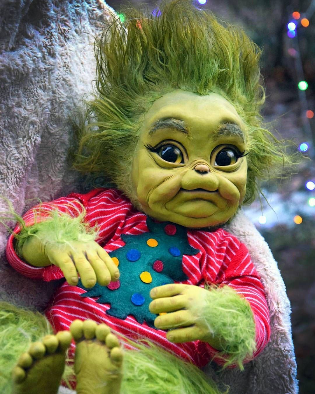 Baby Grinch In Onesies Christmas Attire Wallpaper