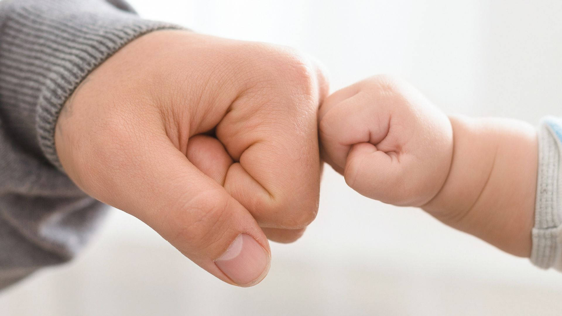 Baby Hand Fist Bumping With Dad Wallpaper