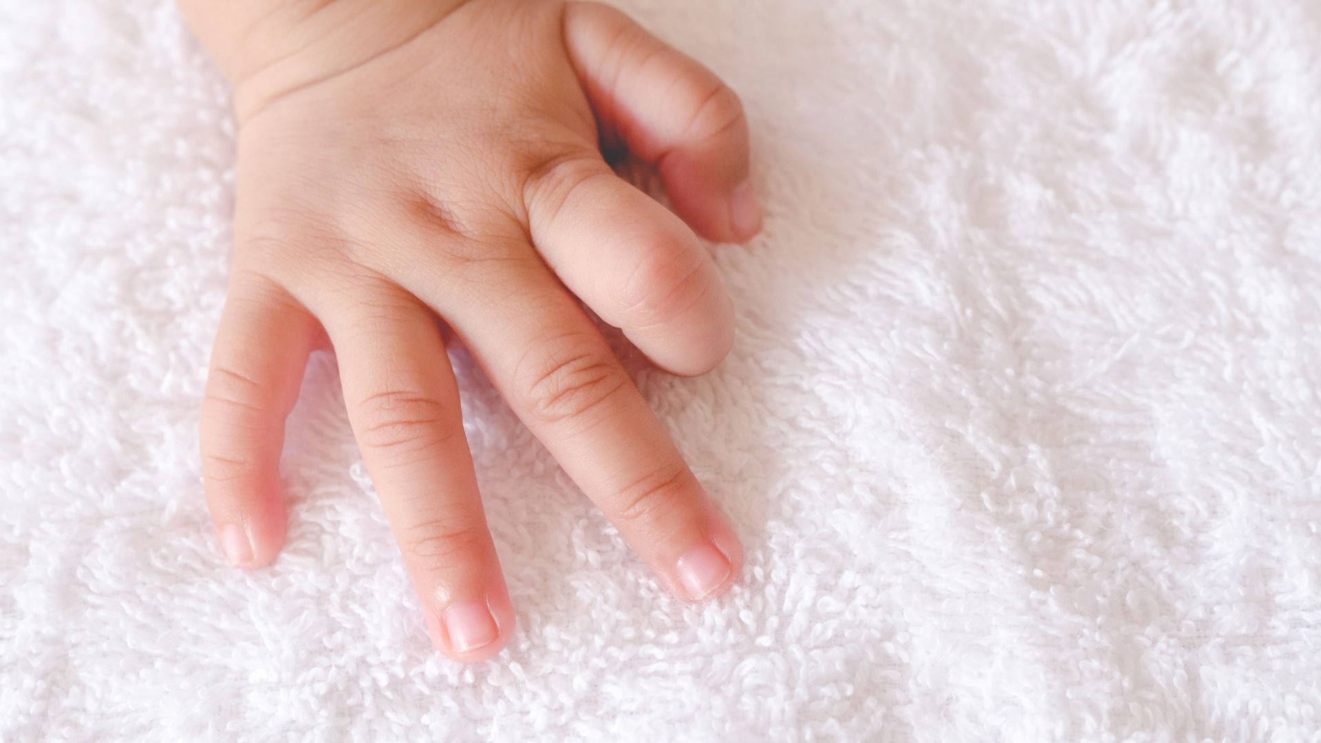 Baby Hand Touching A Soft Fabric Wallpaper