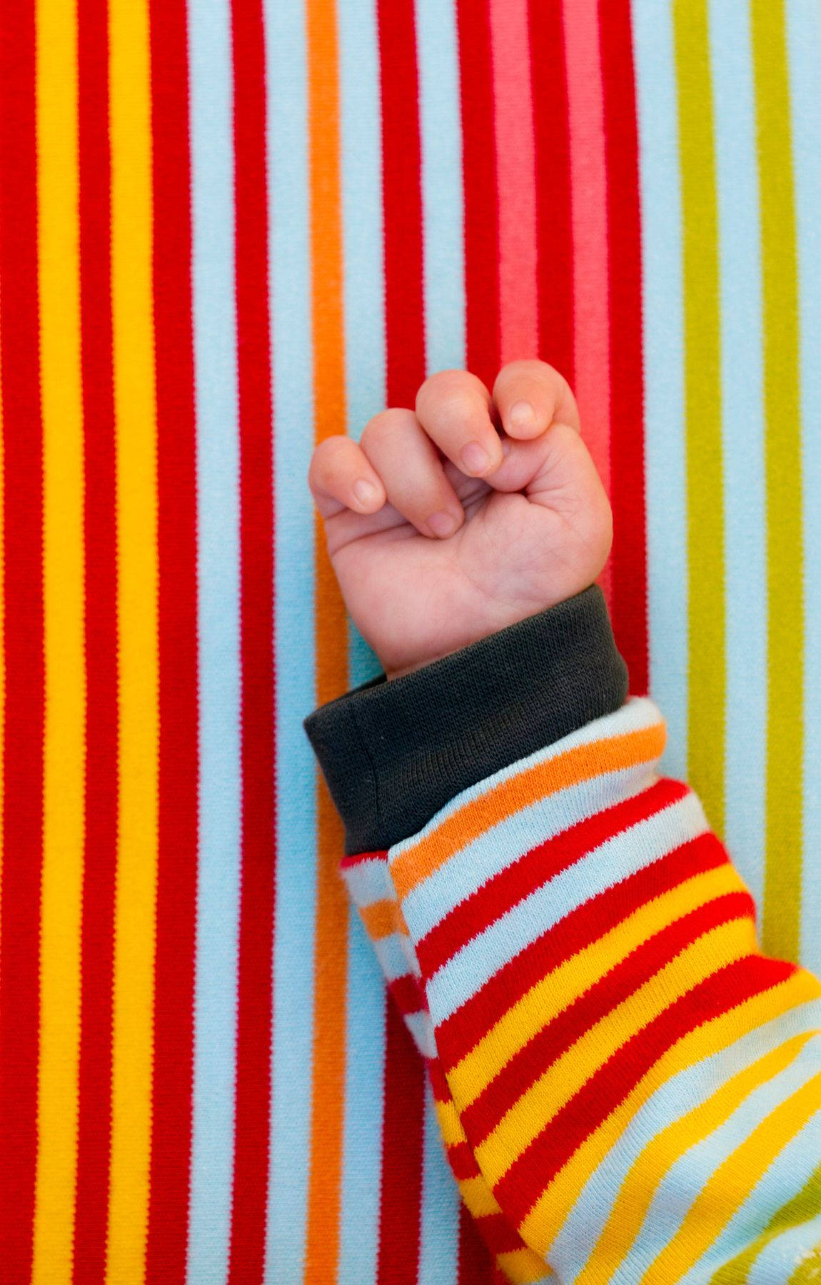 Baby Hand Wearing Colorful Sweater Wallpaper