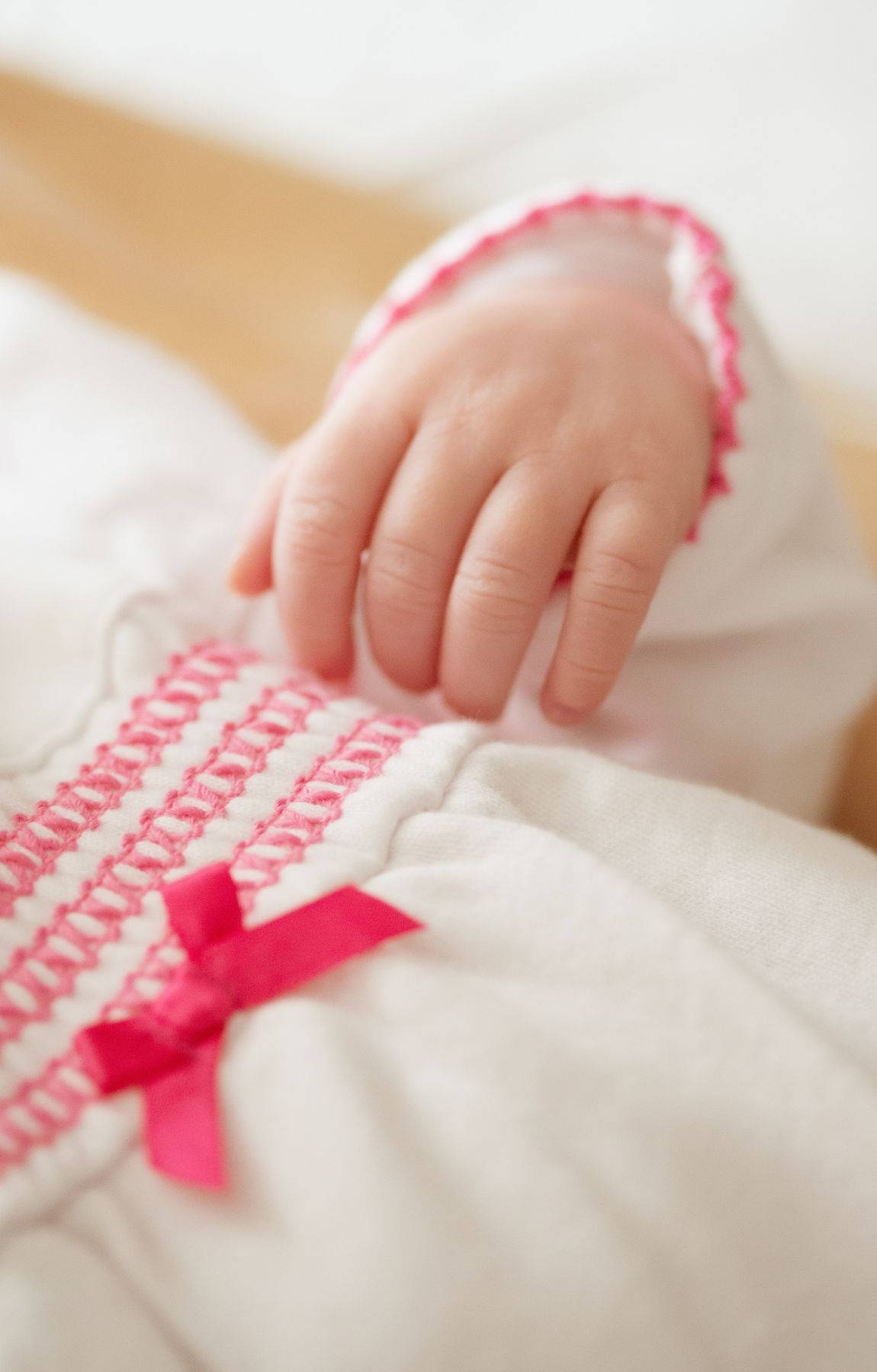 Babyhand In Weißem Und Rosa Kleid Wallpaper