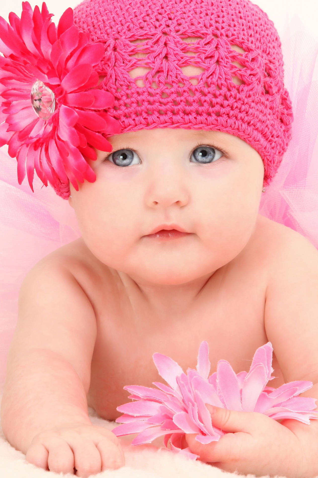 Baby smiles in sweet pink crochet bonnet Wallpaper