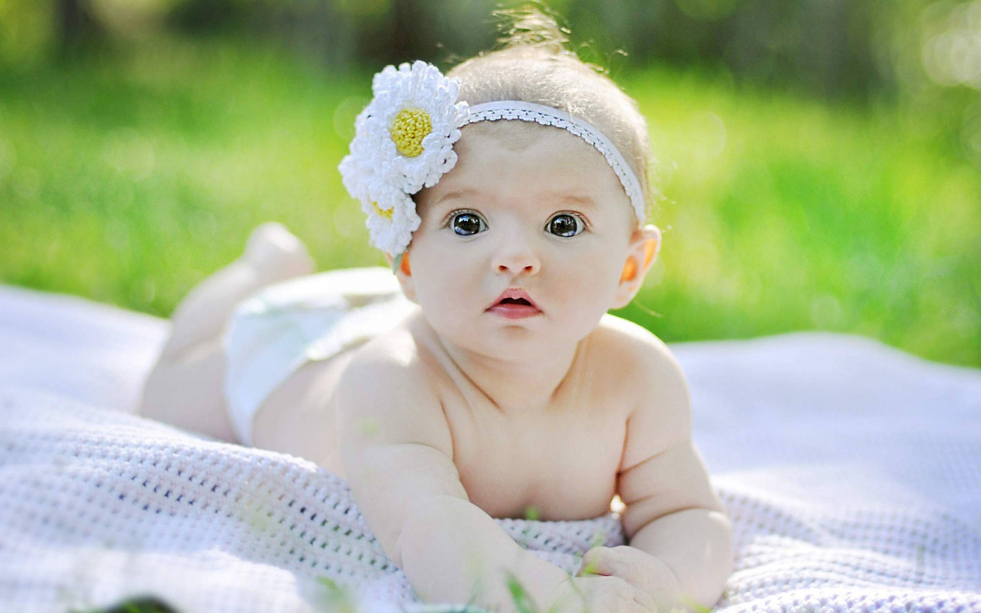 A beautiful baby taking in the sights on a summer day Wallpaper