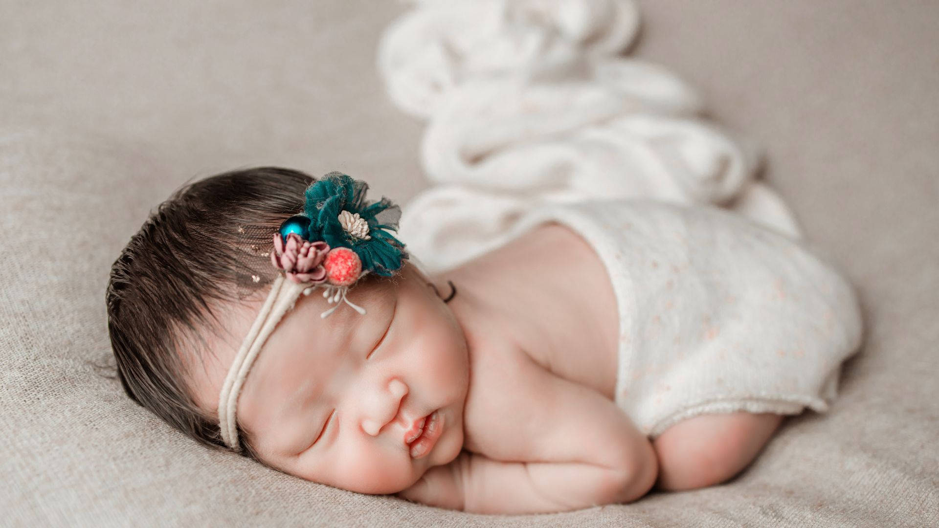 Fotografi af baby sovende nyfødt pige nyder hendes små fødder. Wallpaper