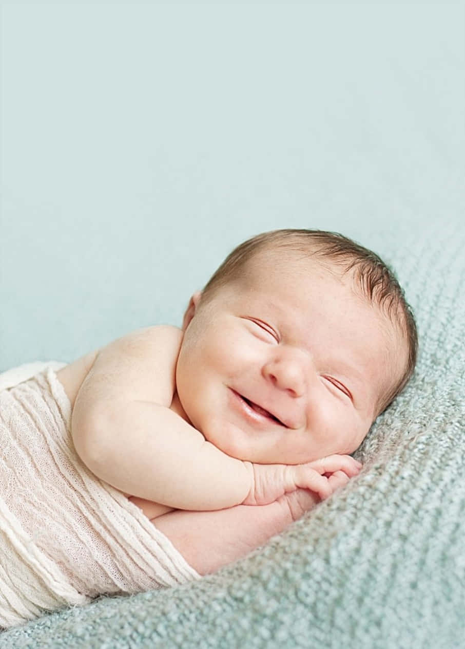Imagende Un Pequeño Bebé Durmiendo Y Sonriendo.