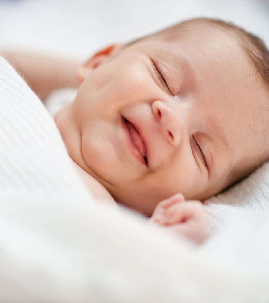 Imagende Un Bebé Durmiendo Y Sonriendo.