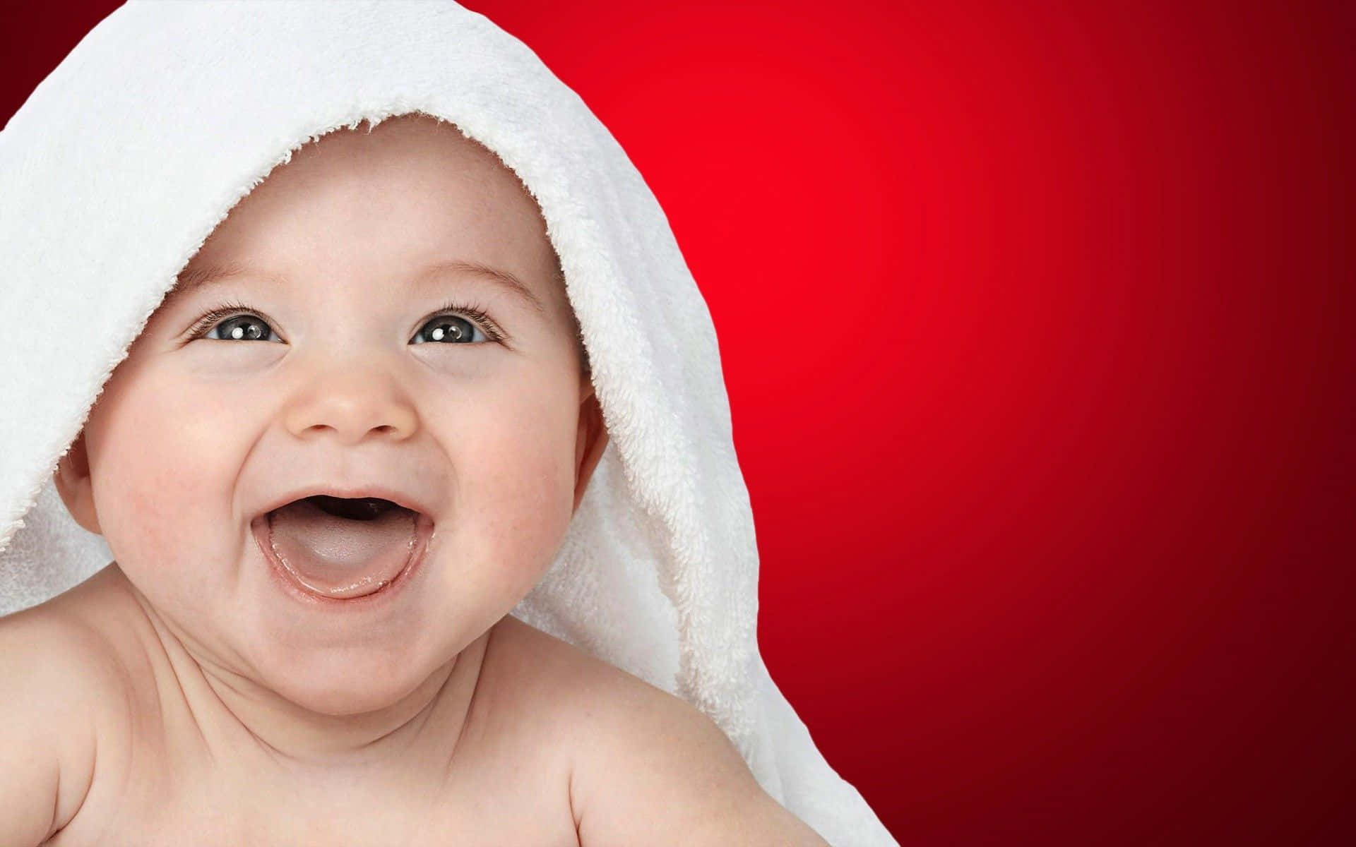 Imagende Fondo Con Bebé Sonriendo En Un Fondo Rojo.