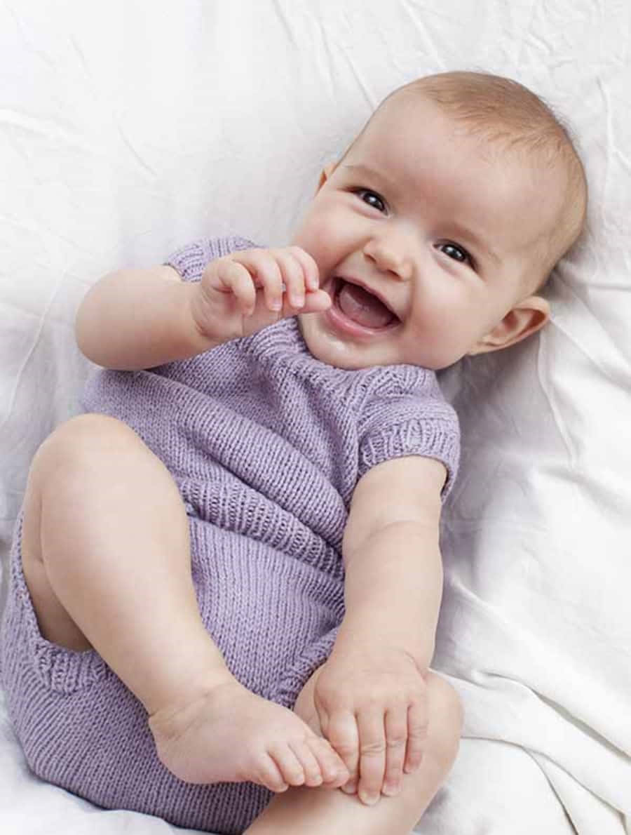 Imagende Un Bebé Sonriendo En La Cama.