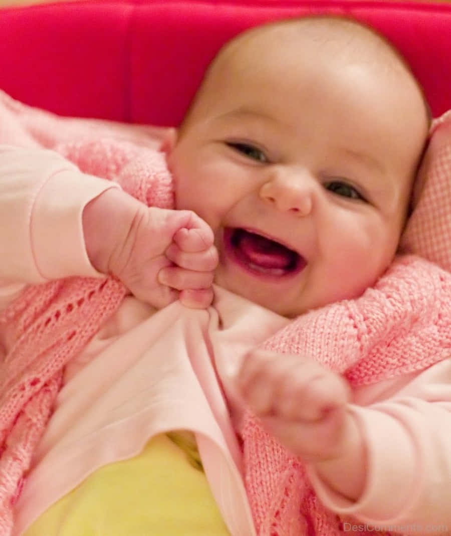 Imagende Un Bebé Sonriendo Llevando Ropa De Invierno.