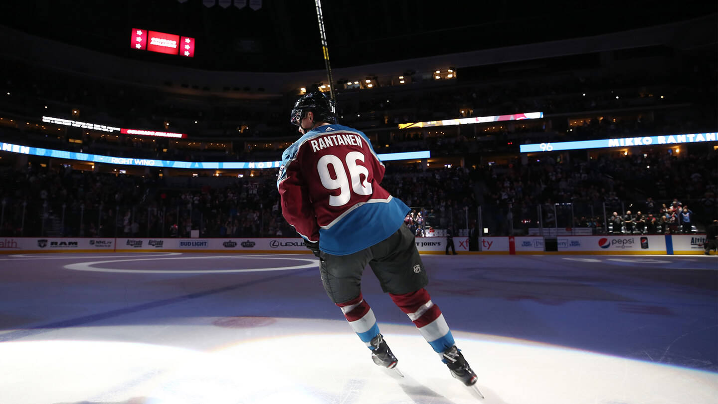 Back Shot Of Mikko Rantanen Leaning To The Left While Holding Hockey Stick Wallpaper