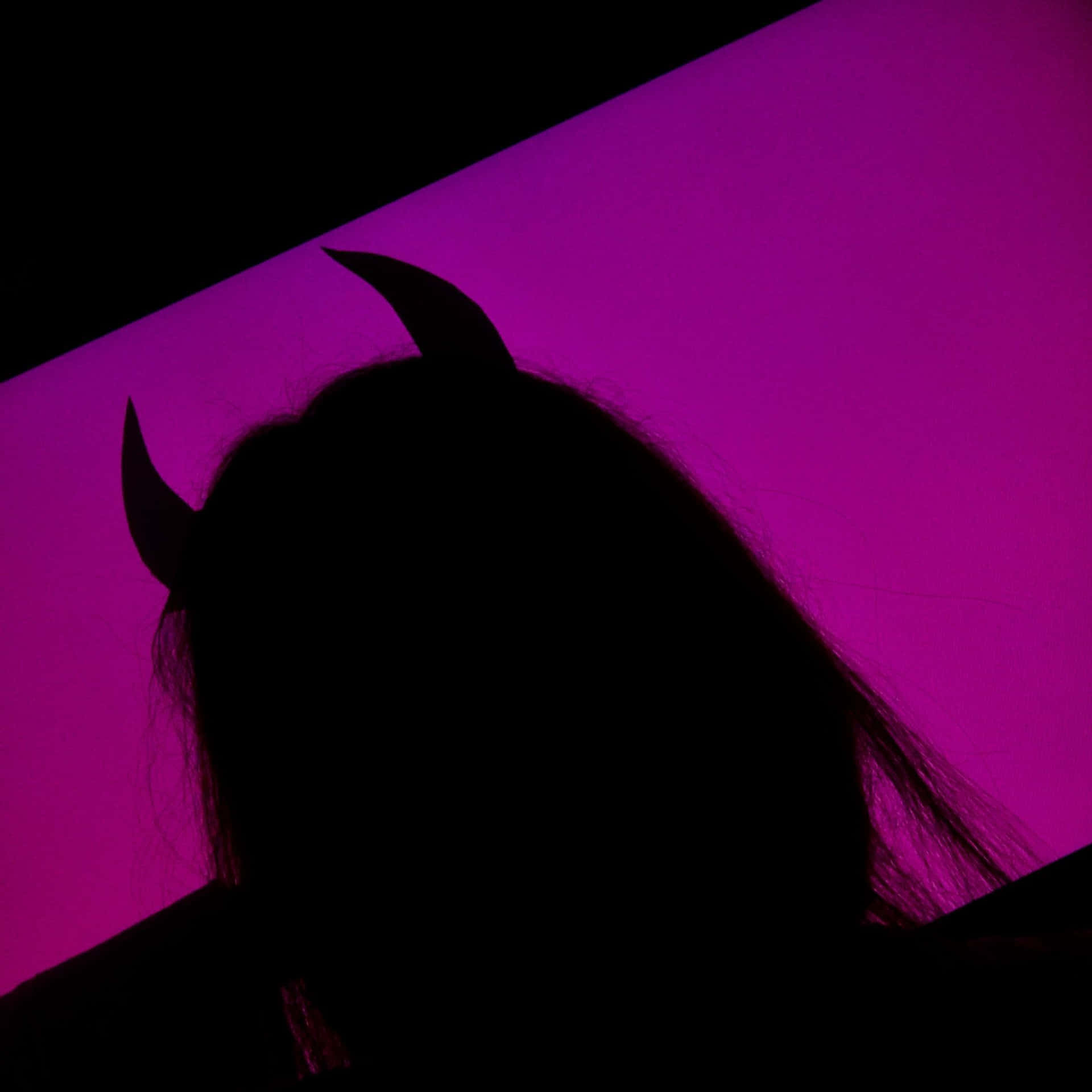 A Silhouette Of A Woman With Horns Wallpaper