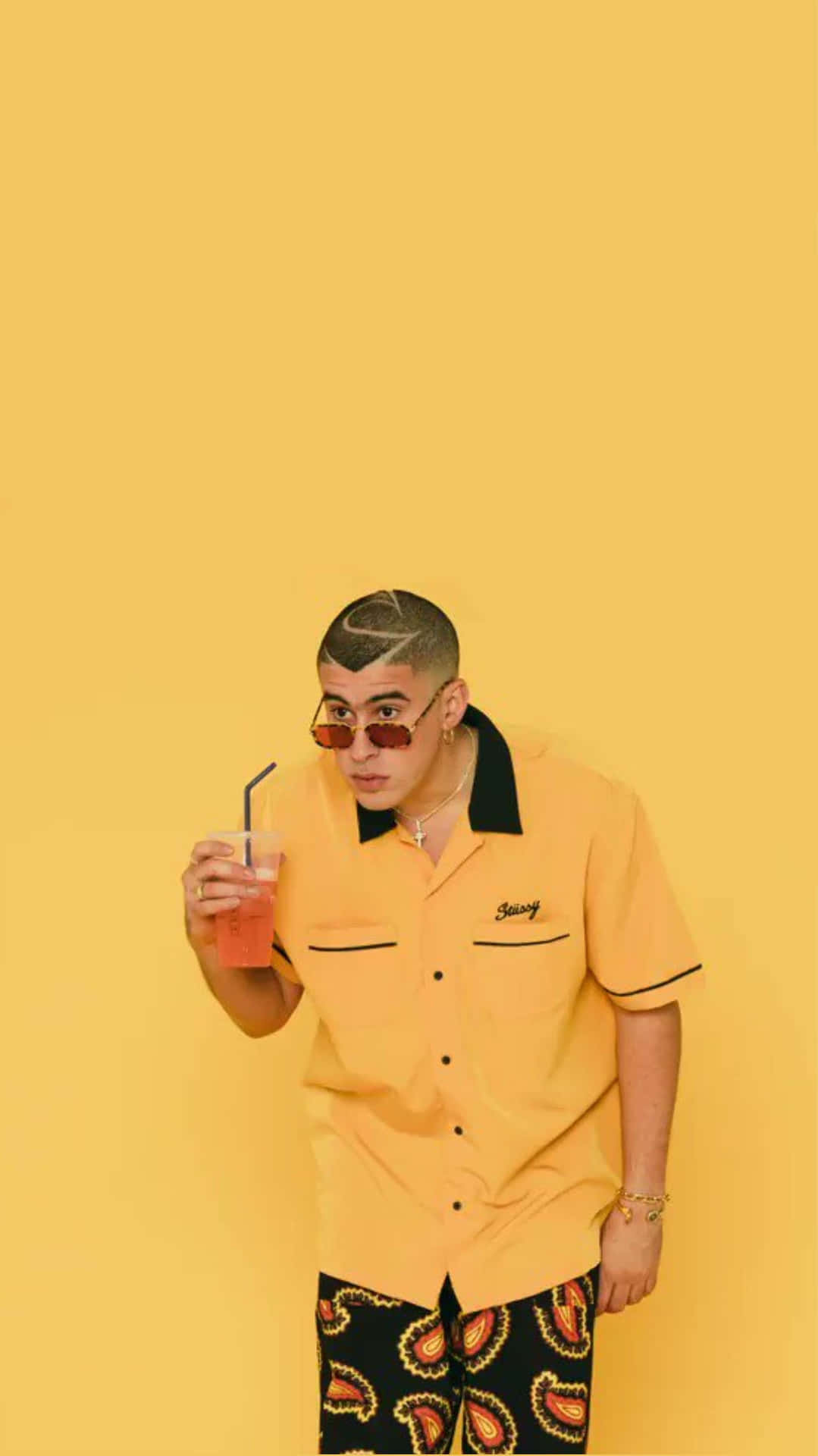 A Man In A Yellow Shirt Holding A Drink