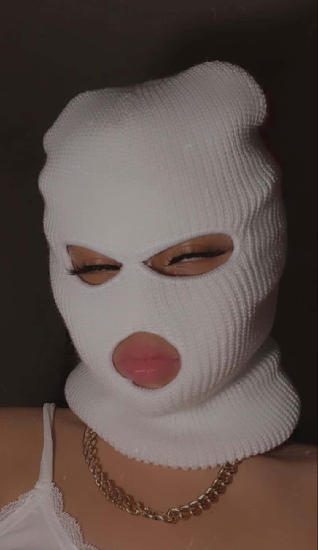 Download A Woman Wearing A White Knitted Mask Wallpaper