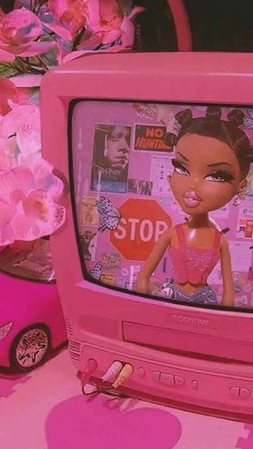 En pink fjernsyn med en dukke siddende ovenpå Wallpaper