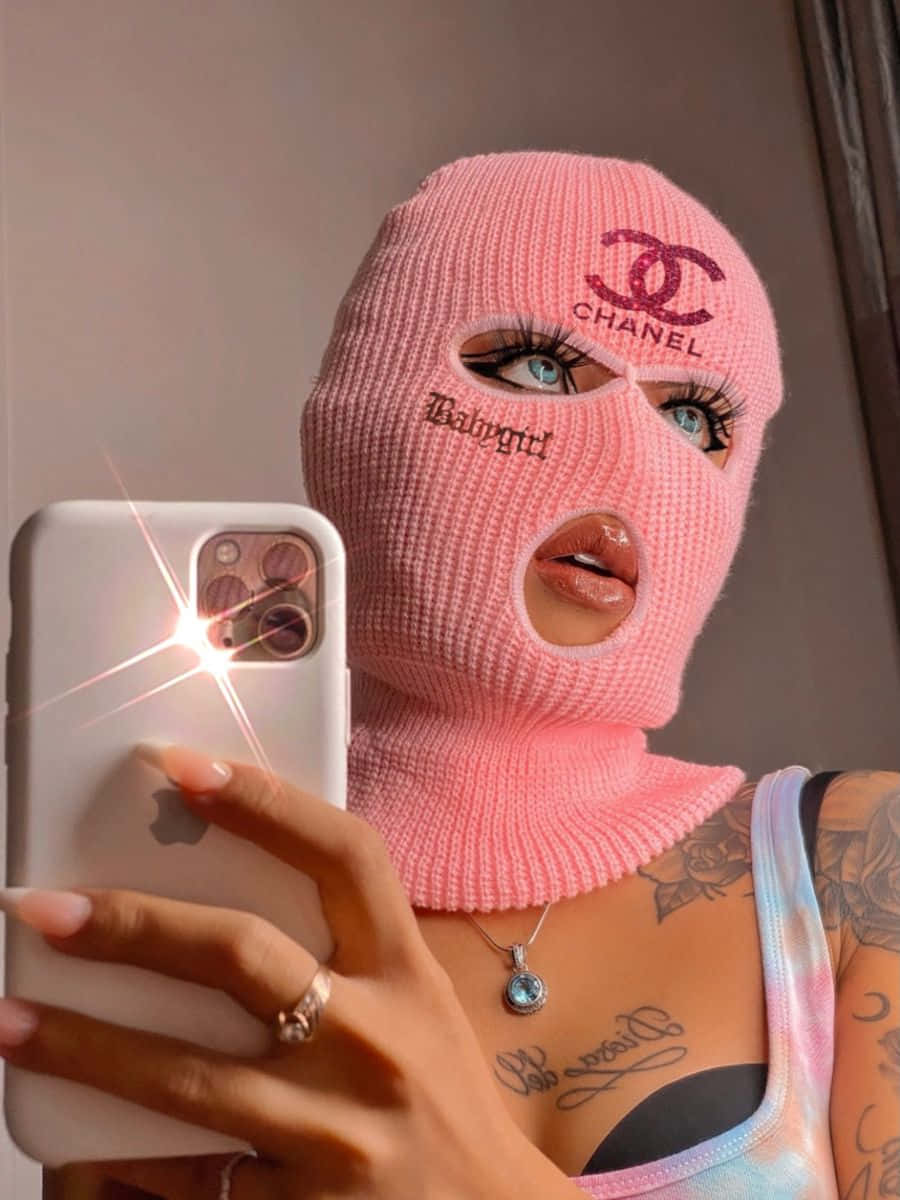 Unamujer Con Una Máscara De Punto Rosa Tomándose Una Selfie. Fondo de pantalla