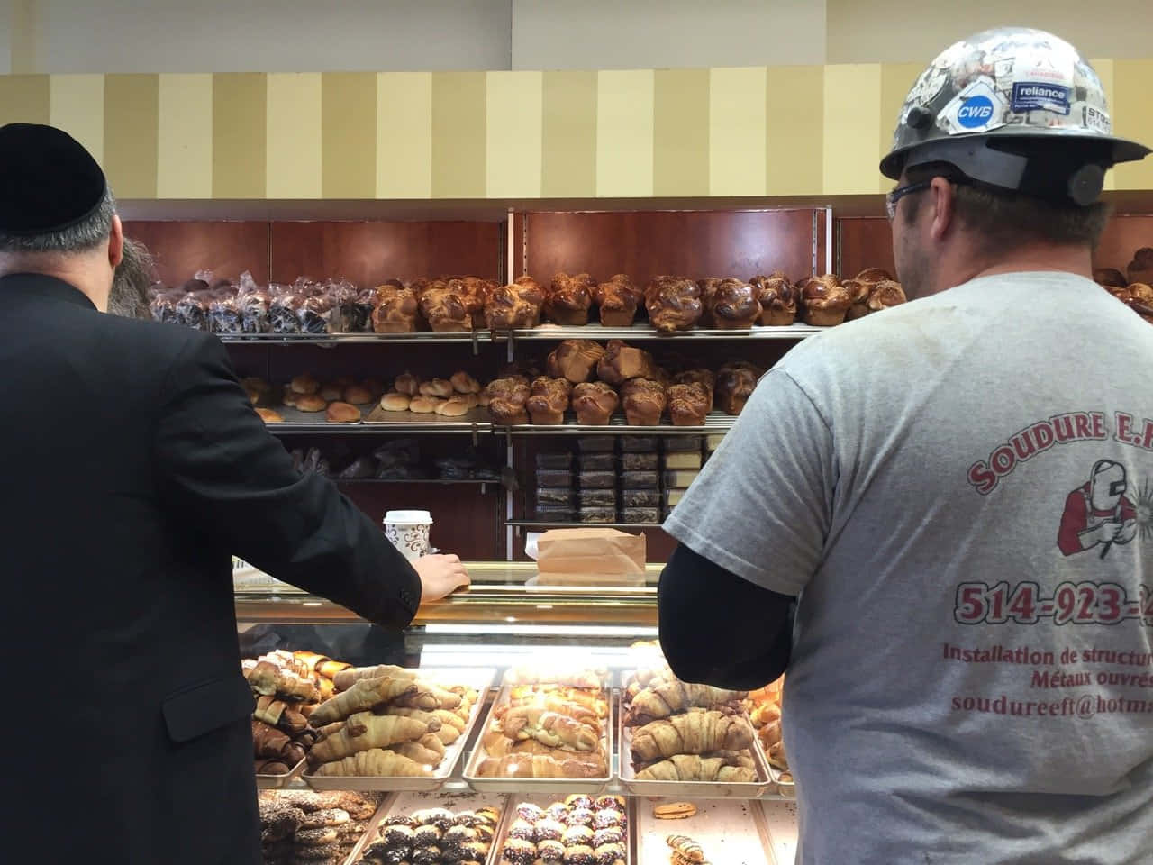 Two Men Standing In Front Of A Bakery
