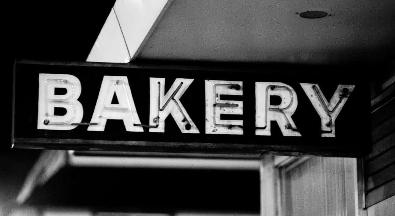 A Black And White Photo Of A Bakery Sign