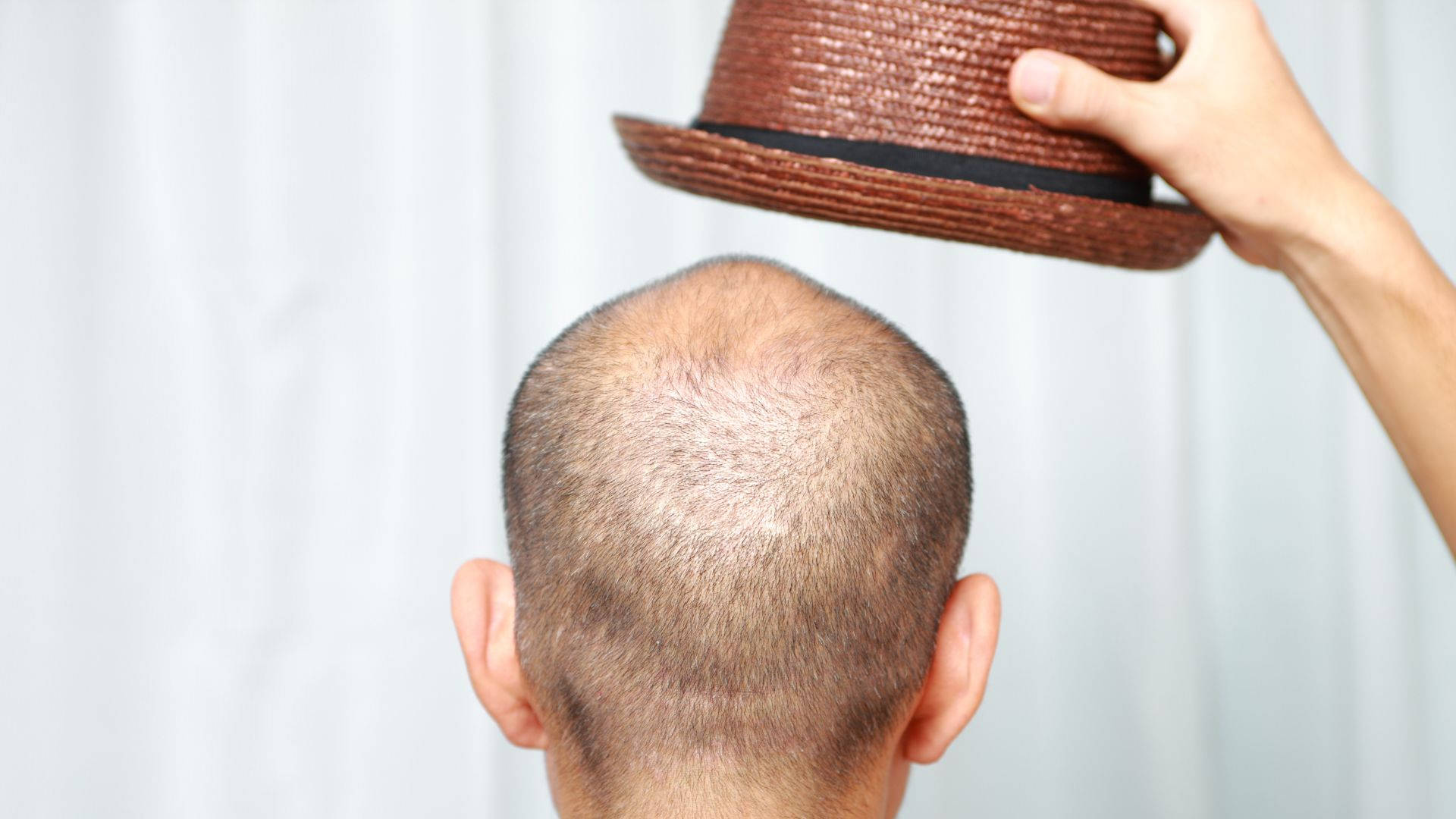 Bald Man Holding A Brown Hat Picture