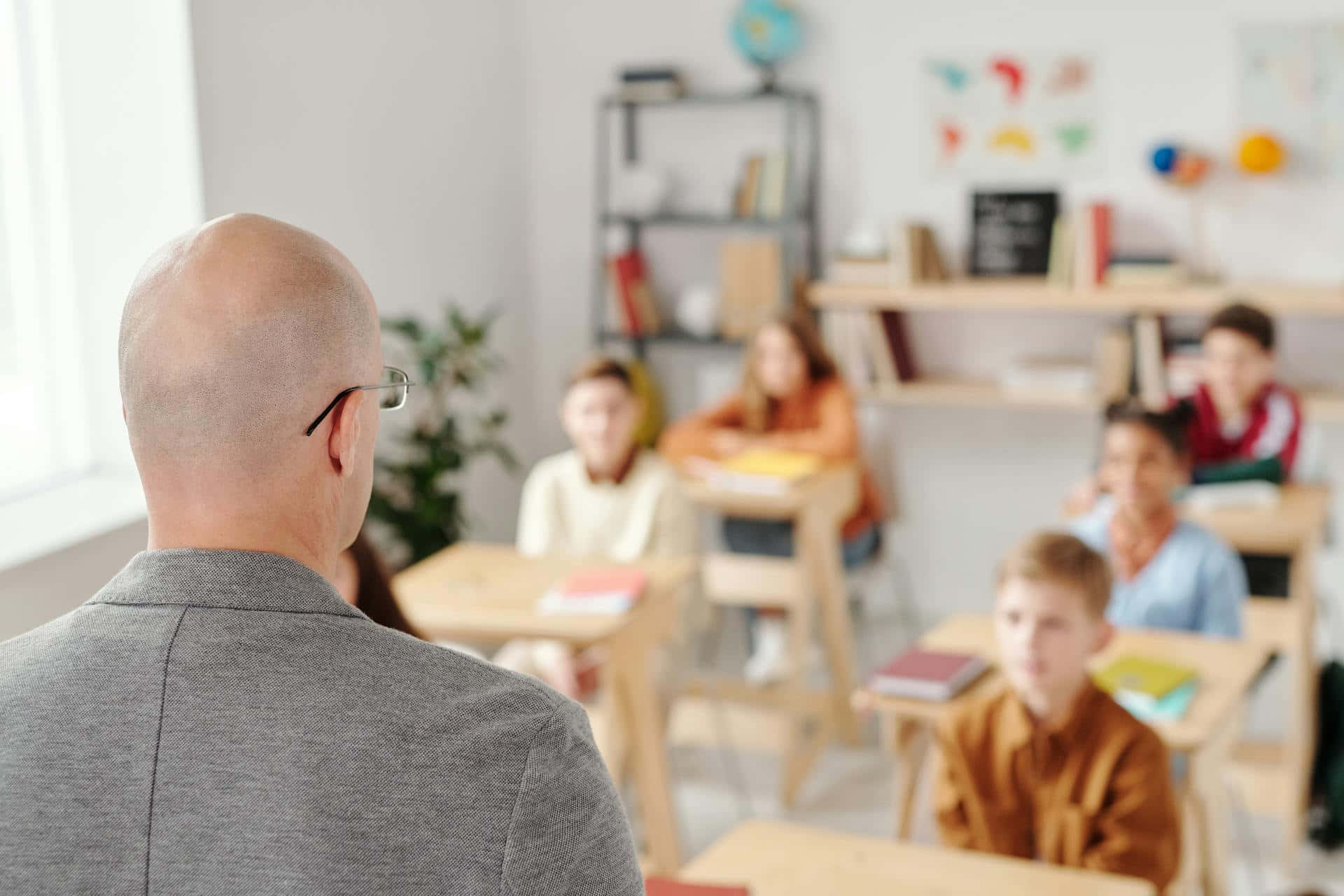 Bald Teacher In Classroom Wallpaper